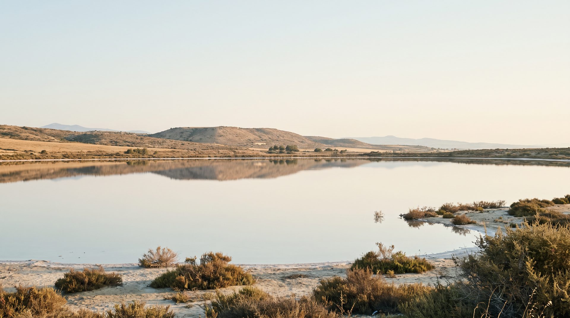 Still salt lake at the edge of dry hills near Larnaca at first light
